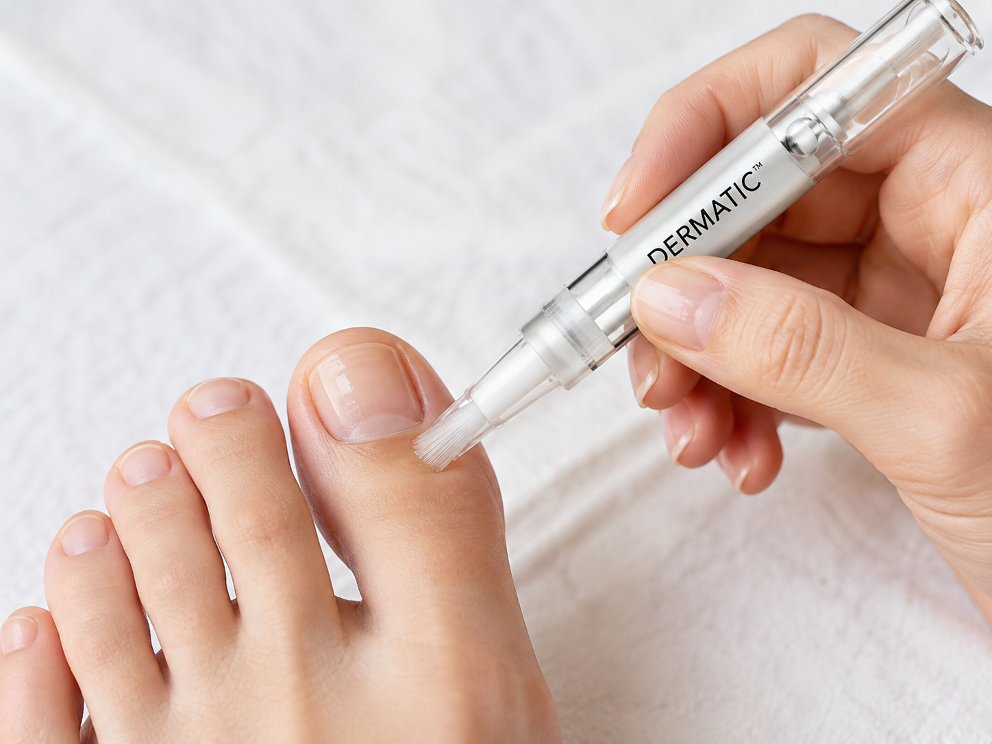 Applying a thin coating of Dermatic to an affected toenail